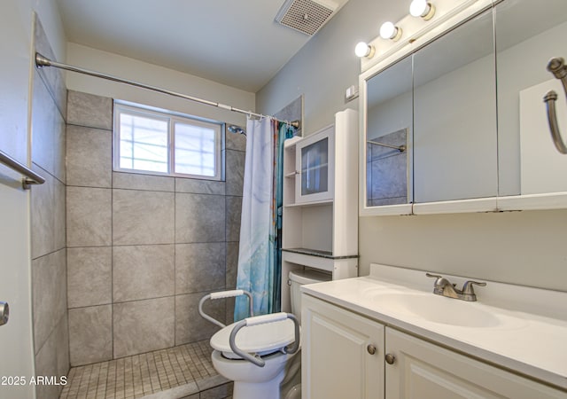 bathroom with visible vents, a tile shower, vanity, and toilet