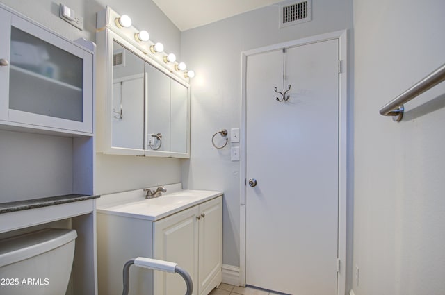 bathroom with toilet, tile patterned flooring, visible vents, and vanity