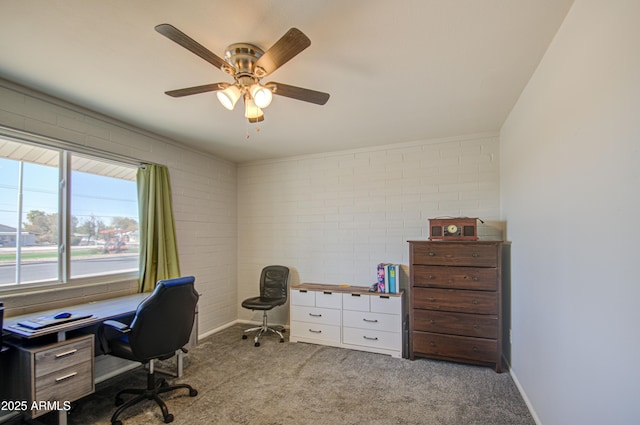 office space featuring baseboards, brick wall, ceiling fan, and light colored carpet