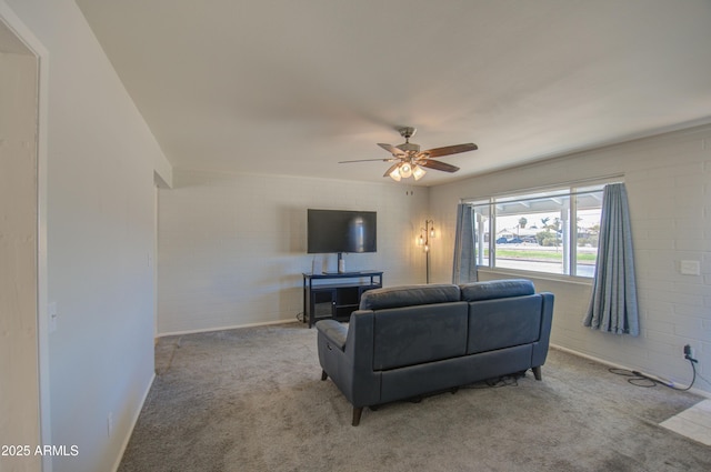 carpeted living area with ceiling fan and baseboards