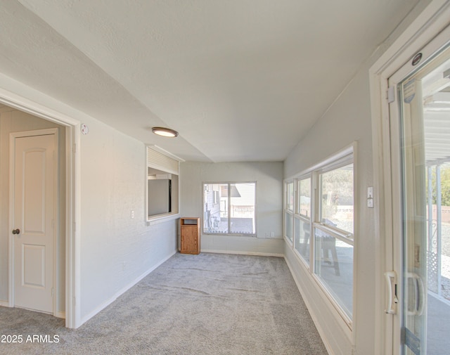 empty room with baseboards and light colored carpet