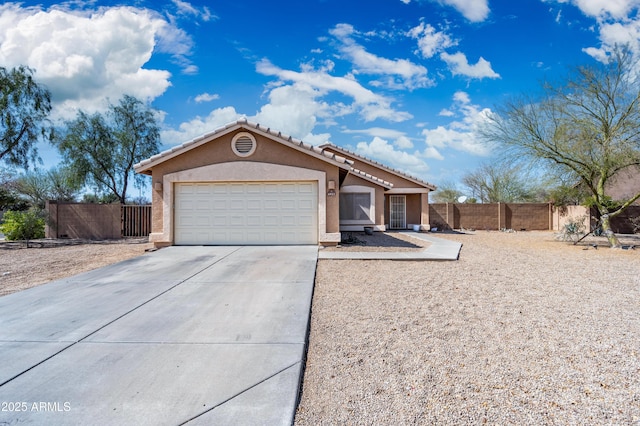 view of front of home featuring an attached garage, fence, concrete driveway, and stucco siding