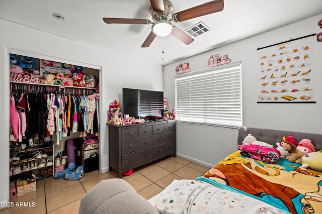 bedroom featuring a ceiling fan, tile patterned flooring, visible vents, and a closet