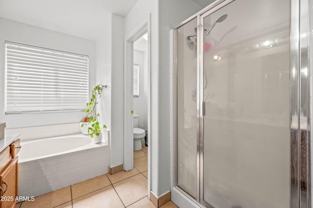 bathroom featuring a garden tub, toilet, a stall shower, vanity, and tile patterned flooring