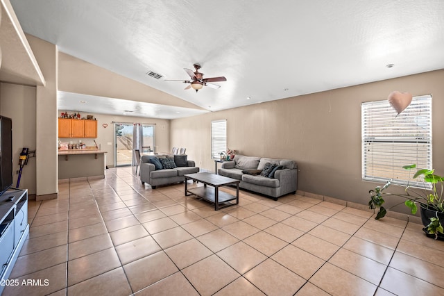 living room with visible vents, lofted ceiling, ceiling fan, a textured ceiling, and light tile patterned flooring