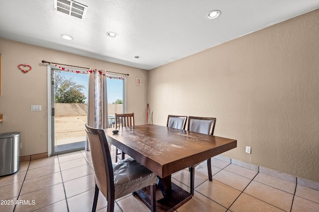 dining room with light tile patterned floors, baseboards, visible vents, a textured wall, and recessed lighting