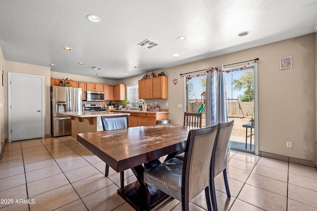 dining room with a wealth of natural light, visible vents, and light tile patterned floors