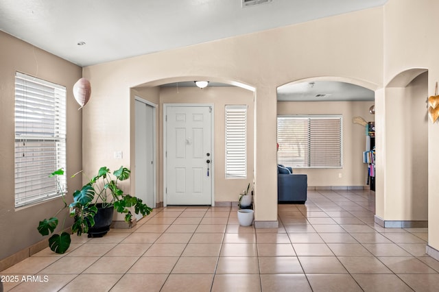 entrance foyer featuring a wealth of natural light, visible vents, baseboards, and light tile patterned floors