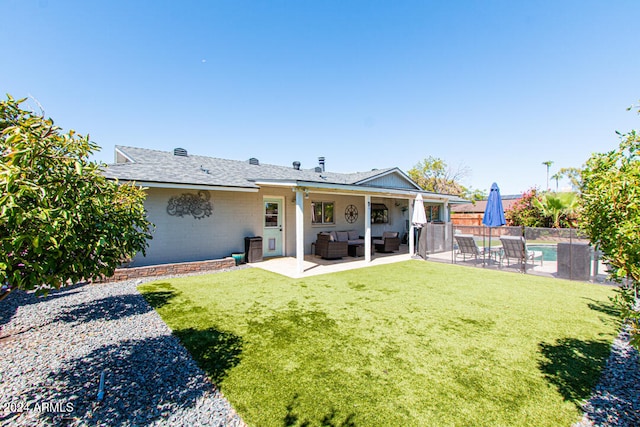 back of house featuring a yard, a patio area, a fenced in pool, and outdoor lounge area