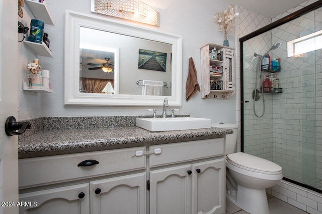 bathroom featuring a shower with shower door, toilet, ceiling fan, tile patterned floors, and vanity