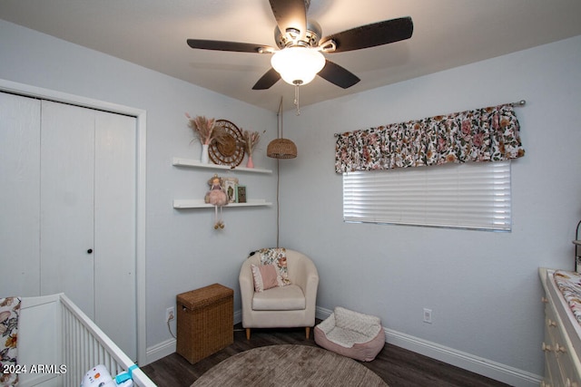 bedroom featuring dark wood-type flooring, a nursery area, a closet, and ceiling fan