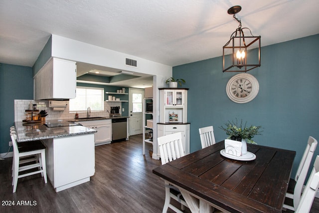 dining space featuring sink, a notable chandelier, dark hardwood / wood-style floors, and a textured ceiling