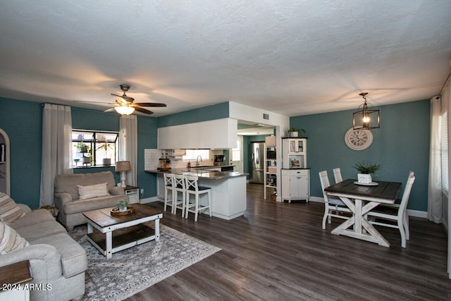 living room featuring sink, ceiling fan, a textured ceiling, and dark hardwood / wood-style flooring