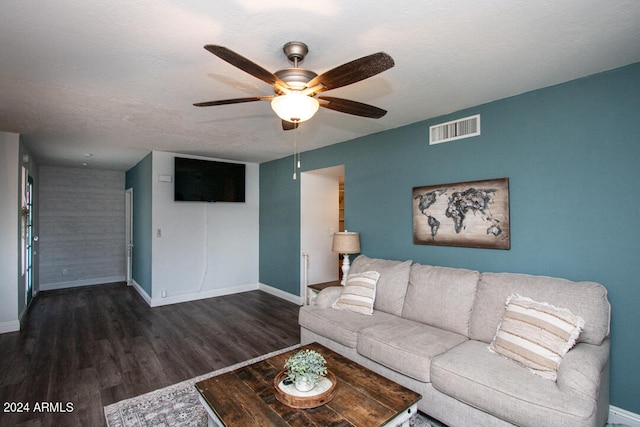 living room with a textured ceiling, ceiling fan, and dark hardwood / wood-style flooring