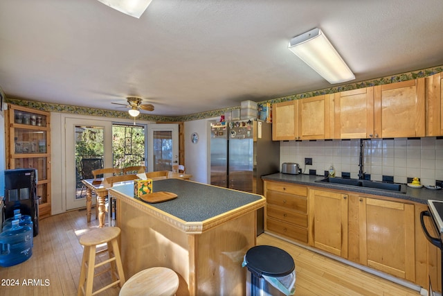 1987 Stagg Run, Overgaard, AZ 85933 - kitchen featuring a center island, sink, a kitchen bar, and light hardwood / wood-style flooring