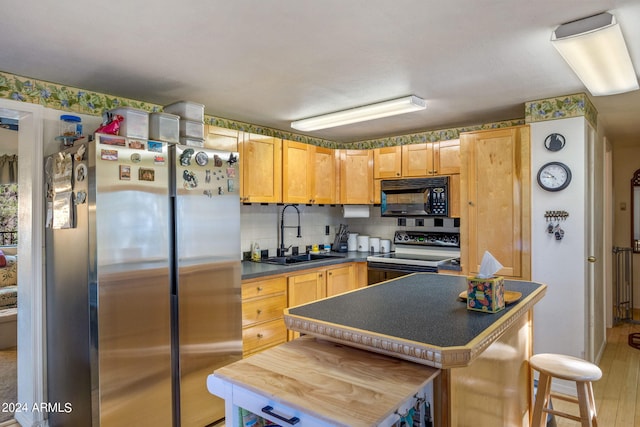 1987 Stagg Run, Overgaard, AZ 85933 - kitchen with light brown cabinetry, sink, a center island, decorative backsplash, and black appliances