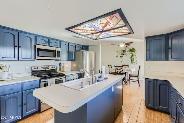 kitchen featuring ceiling fan, stainless steel appliances, light wood-type flooring, and blue cabinets