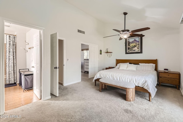 carpeted bedroom featuring ensuite bathroom, high vaulted ceiling, and ceiling fan