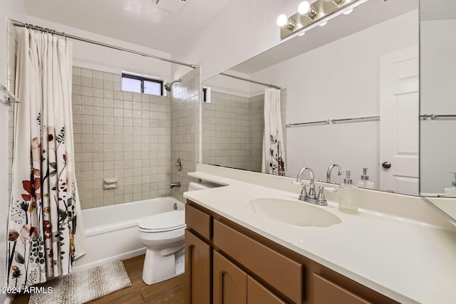 full bathroom featuring vanity, toilet, hardwood / wood-style flooring, and shower / tub combo with curtain