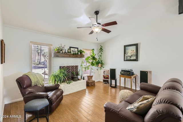 living room featuring crown molding, light hardwood / wood-style flooring, a fireplace, and ceiling fan