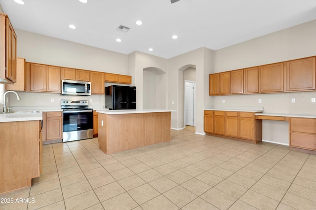 1422 E Ebony Dr, Chandler, AZ 85286 - kitchen with arched walkways, visible vents, a kitchen island, appliances with stainless steel finishes, and a sink