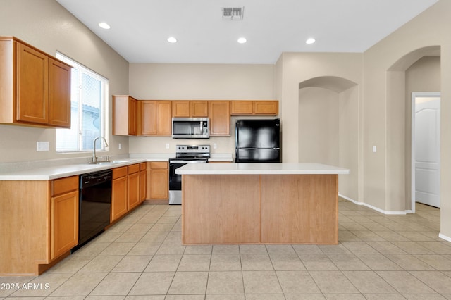 1422 E Ebony Dr, Chandler, AZ 85286 - kitchen with arched walkways, visible vents, black appliances, a kitchen island, and a sink