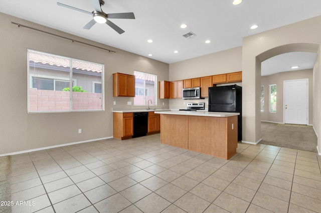 1422 E Ebony Dr, Chandler, AZ 85286 - kitchen with light countertops, a center island, visible vents, arched walkways, and black appliances