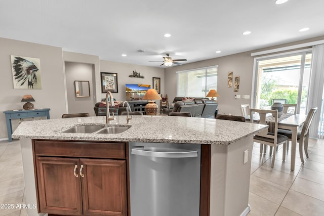 kitchen featuring light tile patterned floors, stainless steel dishwasher, a sink, an island with sink, and ceiling fan