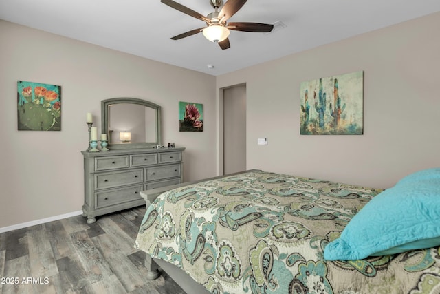bedroom with a ceiling fan, baseboards, and wood finished floors