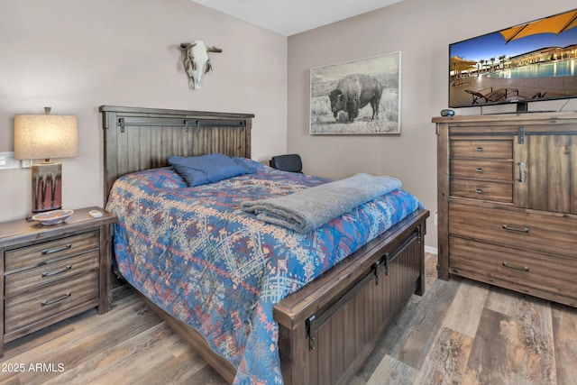 bedroom featuring baseboards and wood finished floors