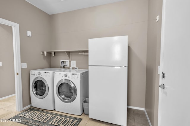 clothes washing area featuring light tile patterned flooring, baseboards, laundry area, and separate washer and dryer