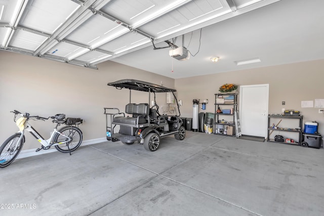 garage featuring a garage door opener and baseboards