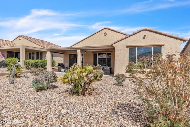 rear view of house with a tile roof, stucco siding, ceiling fan, and a patio