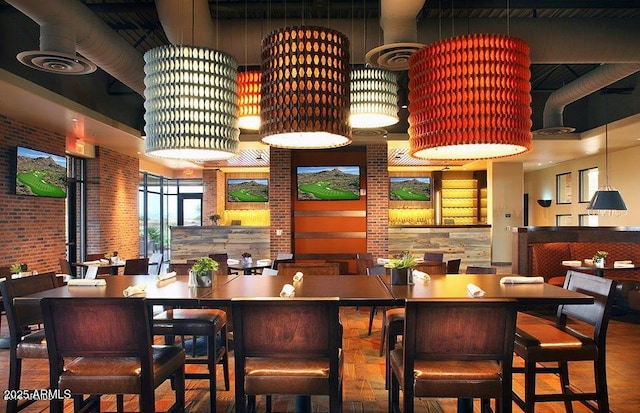 bar featuring visible vents, wood finished floors, and brick wall