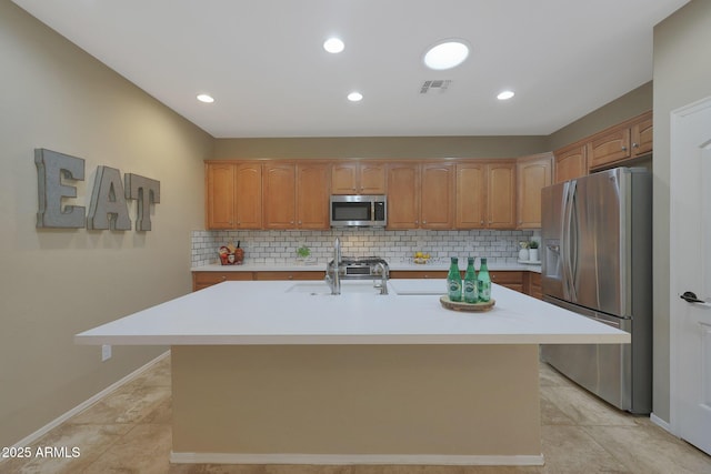 kitchen featuring tasteful backsplash, light tile patterned floors, stainless steel appliances, and a kitchen island with sink