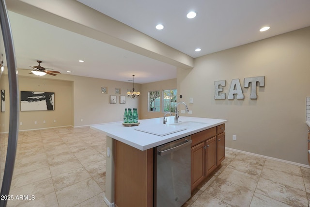 kitchen featuring decorative light fixtures, a center island with sink, stainless steel dishwasher, sink, and ceiling fan with notable chandelier