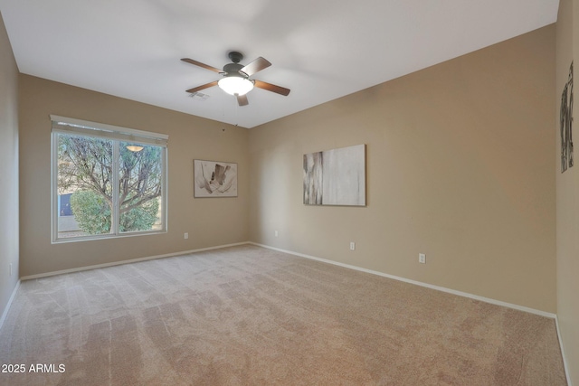 empty room with ceiling fan and light colored carpet