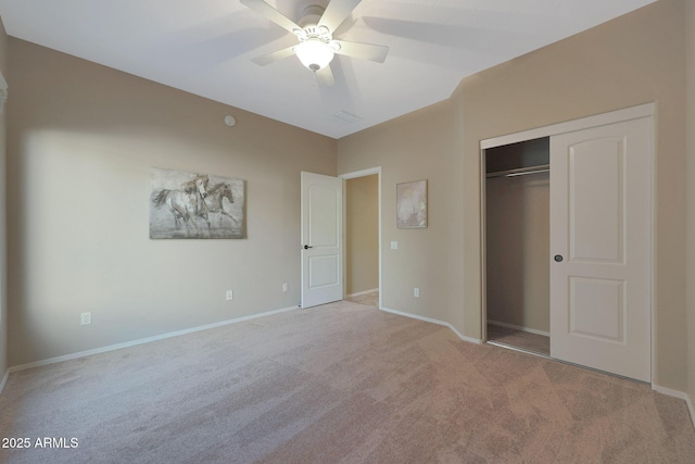 unfurnished bedroom featuring ceiling fan, a closet, and light carpet