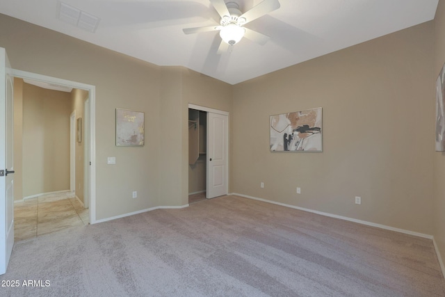 unfurnished bedroom featuring ceiling fan, light colored carpet, and a closet