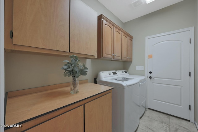 laundry room with light tile patterned flooring, cabinets, and washing machine and clothes dryer