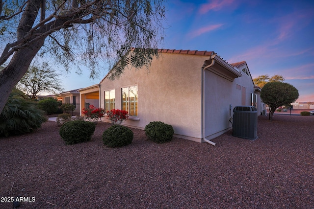 property exterior at dusk with cooling unit