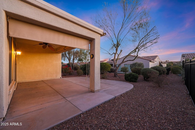 patio terrace at dusk featuring ceiling fan