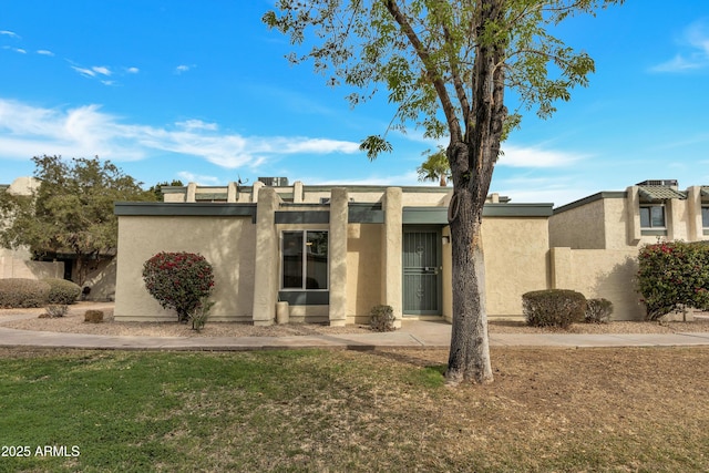 view of front of house with a front lawn and stucco siding