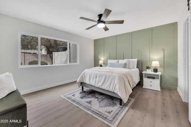 bedroom with a ceiling fan, baseboards, and wood finished floors