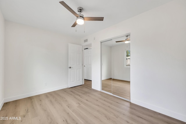 unfurnished bedroom with light wood-style floors, baseboards, visible vents, and a closet