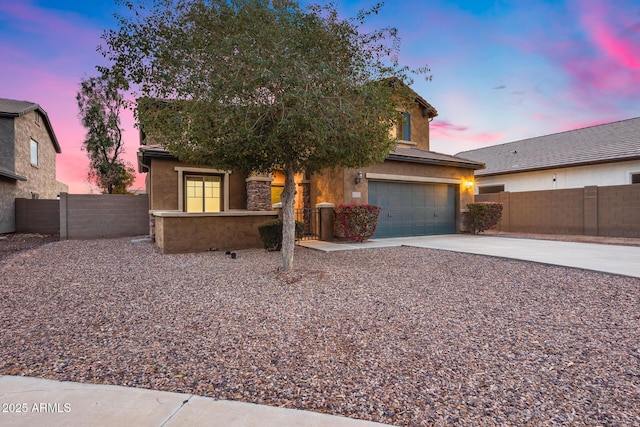 view of property hidden behind natural elements featuring a garage, concrete driveway, a gate, fence, and stucco siding