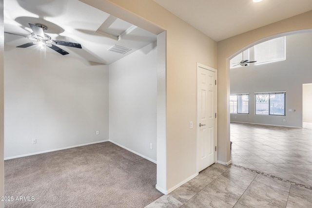 empty room with ceiling fan, baseboards, visible vents, and tile patterned floors