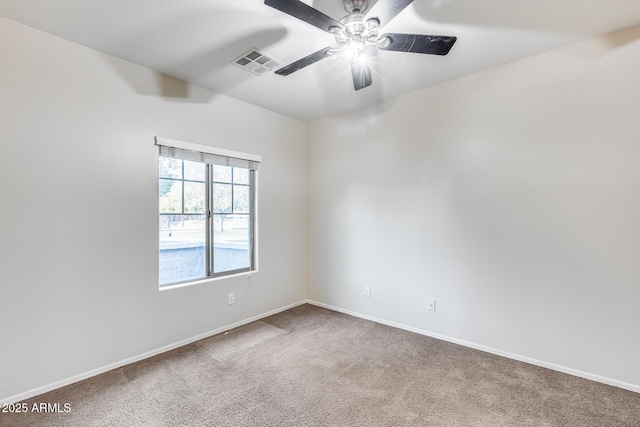 carpeted empty room featuring visible vents, ceiling fan, and baseboards