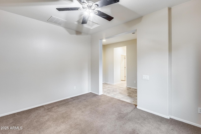 carpeted spare room featuring visible vents, ceiling fan, and baseboards