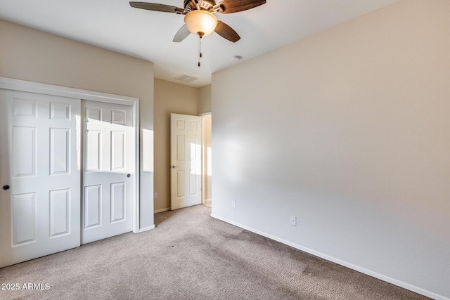 unfurnished bedroom with ceiling fan, visible vents, baseboards, a closet, and carpet